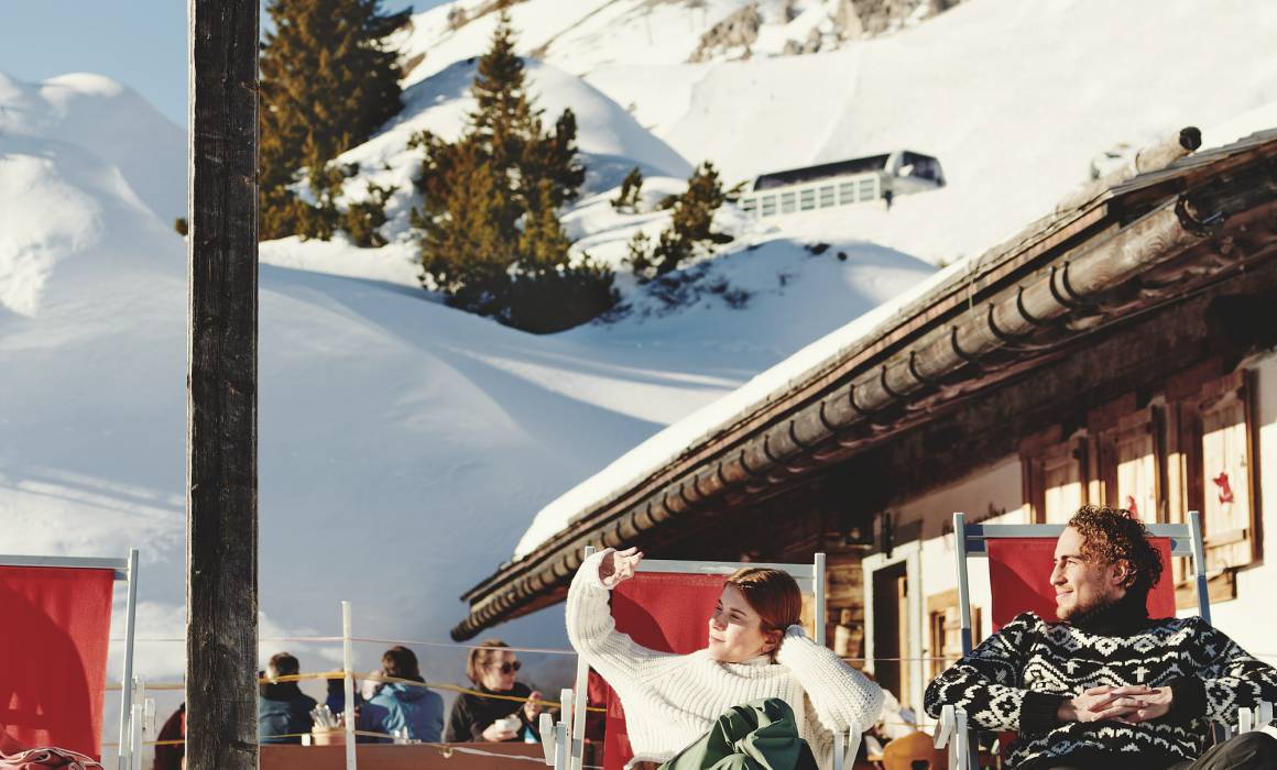 Skiers relax at the "Kriegeralpe" mountain hut in winter in the snow